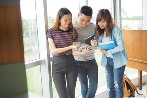 Student groups are viewing information in the tablet. Having a gesture of agreement and smiling, happy to study together. photo