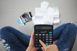 Women sit stressed with the calculator calculates receipts expenses. To repay credit card debt. photo