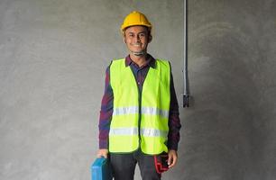 ingeniero asiático o contratista principal con cascos y abrigos foto