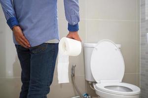 Working men have abdominal pain and diarrhea. Prepare toilet paper holder to go to shit. photo