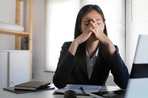 las mujeres trabajan demasiado, usan sus manos para tocarse los ojos, tienen visión borrosa, mareos después de un largo período de trabajo. foto