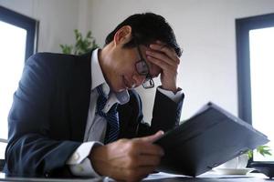 The owner has a stressful face while looking at the business turnover with loss. photo