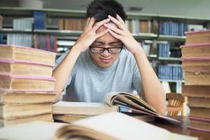 los estudiantes están estresados con mucho estudio y lectura en la biblioteca. foto