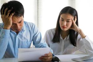 marido y mujer asiáticos están estresados con la factura. problemas de préstamo que causan una gran cantidad de deuda