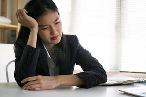 los empresarios asiáticos tienen dolor de cabeza porque la oficina se siente incómoda en el trabajo. foto