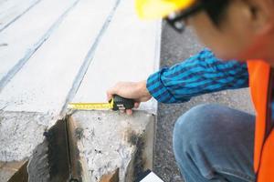 The chief contractor uses a meter tape to check the size of the stake. photo