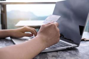 Women's hands are using computers and credit cards to order products online. photo