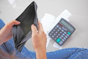 mano de mujer con billetera vacía. calcular el costo de la deuda de la tarjeta de crédito. foto
