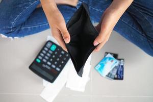 Woman's hands open empty purse. Poverty, debt and bankruptcy in the payment of bills and credit cards. Broke concept photo