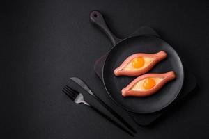 Composite concept of fried eggs inside a cut sausage with spices photo