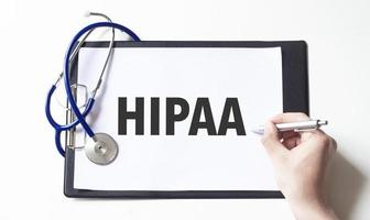 Doctor holding a pen and card with text hipaa, medical concept photo