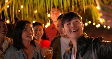imágenes de amigos asiáticos felices cenando y tomando selfie juntos - jóvenes brindando con vasos de cerveza cenando al aire libre - gente, comida, estilo de vida de bebida, concepto de celebración de año nuevo. video
