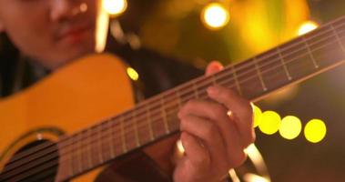 Footage close up of Happy young Asian man playing a guitar in night party  - People, food, drink lifestyle, new year celebration concept. video