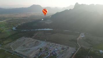 Heißluftballon-Epos, das bei Sonnenaufgang über dem Berg über dem Nebel fliegt, mit schönem Himmelshintergrund. horizontale Ausrichtung aus der Luftperspektive. Luftdrohne in großer Höhe Weitblick.