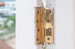 bisagras doradas en la protección de puertas blindadas, cerrojo metálico en ventana de madera foto