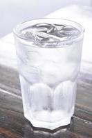 glass of water with ice on wooden table , clean water,drinking water photo