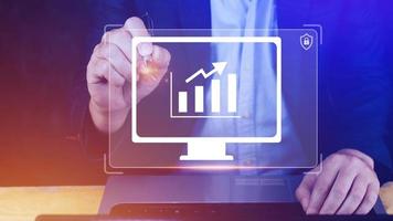 Businessman showing business growth on graph Hands touching graphs representing increasing profits with virtual interface technology, financial symbols coming photo