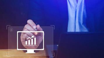 Businessman showing business growth on graph Hands touching graphs representing increasing profits with virtual interface technology, financial symbols coming photo