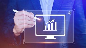 Businessman showing business growth on graph Hands touching graphs representing increasing profits with virtual interface technology, financial symbols coming photo