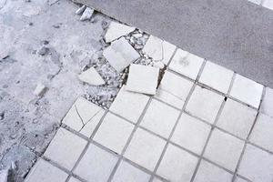 Clean white broken tile wall texture background.Tile floor exploded and cracked because used for a long time,Repairing tiles in the house photo