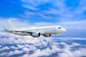 avión en el cielo, avión comercial de pasajeros volando sobre las nubes, concepto de viaje rápido, vacaciones y negocios. foto