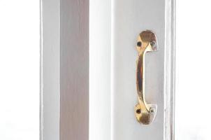 Golden Stainless steel vintage style handle on painted wooden white window, Furniture handles photo