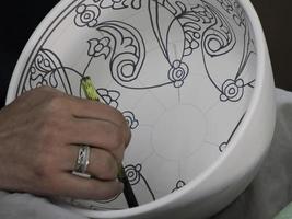 Moroccan Craftsman painting and decorating ceramic products in pottery factory in Fez, Morocco photo