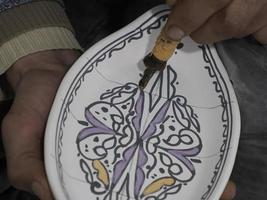 Moroccan Craftsman painting and decorating ceramic products in pottery factory in Fez, Morocco photo