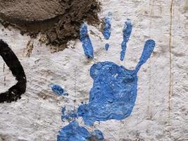 impresión de mano de color azul en la pared blanca foto