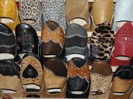 Colorful handmade leather slippers waiting for clients at shop in Fes, next to tanneries, Morocco photo