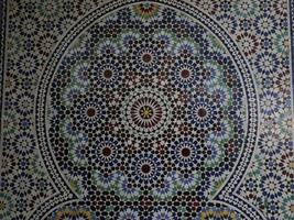 Mosaico marroquí artesano pintando y decorando productos cerámicos en la fábrica de cerámica en Fez, Marruecos foto