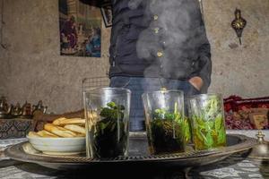 Moroccan mint tea served in the traditional way in a glass from a silver teapot old ritual photo