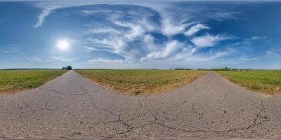 full spherical seamless hdri 360 panorama view on no traffic old asphalt road with cracks among fields with sky and clouds in equirectangular projection, VR AR content. May use like sky replacement photo