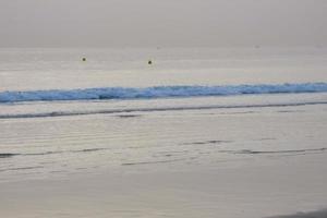 lonely, uncrowded beach with calm sea and small waves photo