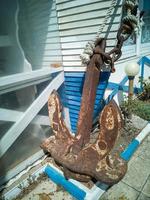 Old abandoned rusty iron ship anchor. Street decoration photo