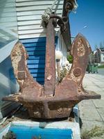 Old abandoned rusty iron ship anchor. Street decoration photo