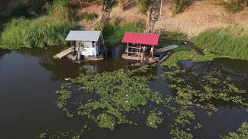 Water pump houses with green and blue roof by the river. video