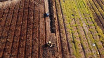 antenn se av en hjul lastare grävmaskin med en traktor läser in sand in i en tung earthmover på en konstruktion webbplats. grävmaskin grävning jord gropar för de jordbruks industri. video