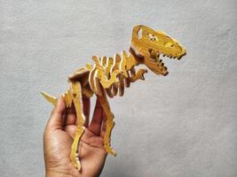 Side view of a  hands playing figures of prehistoric animals. Wooden miniature dinosaurs resource use concept for teaching. photo