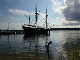 old boat docked on river or lake water with old anchor photo