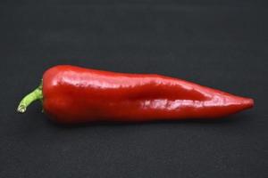 Large red capsicum on a black background. Hot red pepper. Capsicum. photo