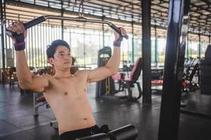 hombre asiático haciendo ejercicio con una barra en el gimnasio foto