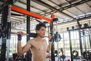 Man doing squat exercises with a barbell in gym photo