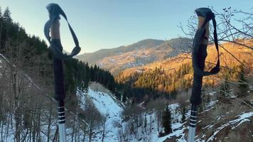 zoom en el panorama del paisaje bastones de senderismo en la ruta de senderismo con panorama de las montañas nevadas del cáucaso en la brillante y cálida noche de primavera durante la puesta de sol. la nieve se derrite llega la primavera video