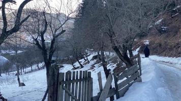 Male person walk on ice road to village in mountains video