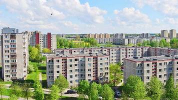 zoom uit zomer time-lapse antenne visie zuidelijk een deel van siauliai stad in litouwen.oud Sovjet unie gebouwen met groen natuur in de omgeving van en yards vol van auto's in een zonnig dag. video