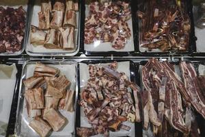 Categorized raw meat with bone on a storefront. Raw meat with beef bone. Beef bone selection for soup photo