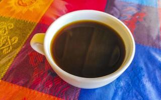 café en taza sobre mantel colorido en mazunte mexico. foto