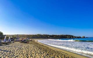 Puerto Escondido Oaxaca Mexico 2023 Palms parasols sun loungers beach waves Puerto Escondido Mexico. photo