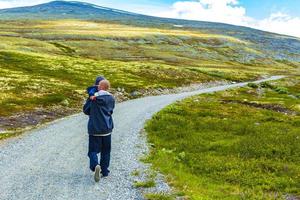 padre excursionista con niño montañas paisaje parque nacional de rondane noruega. foto